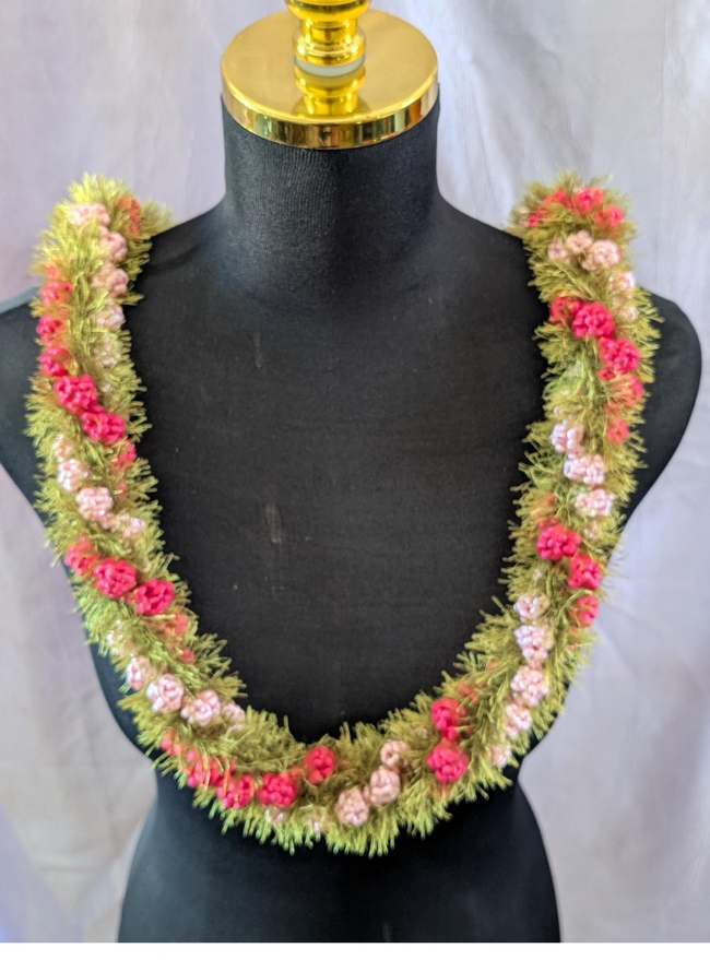 Crochet lei in gold and red on mannequin